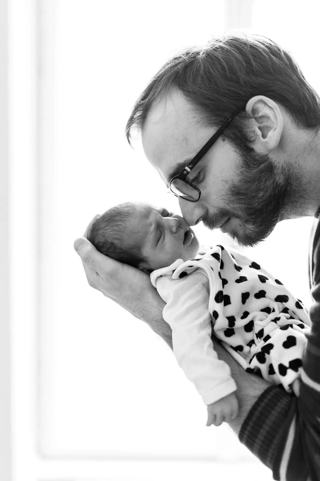 Babyfoto eines schlafenden Babys auf dem Arm seines Vaters