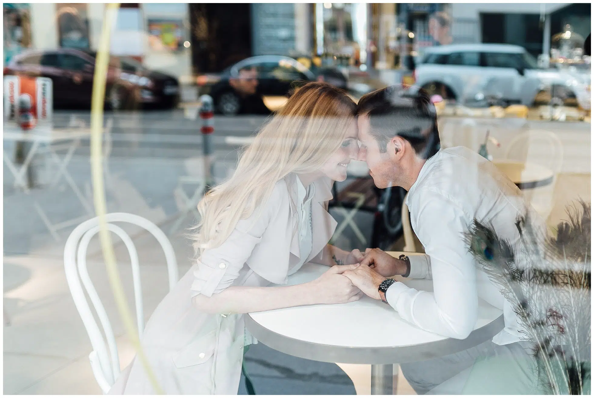 Verliebtes Paar durch die Scheibe eines Cafés fotografiert