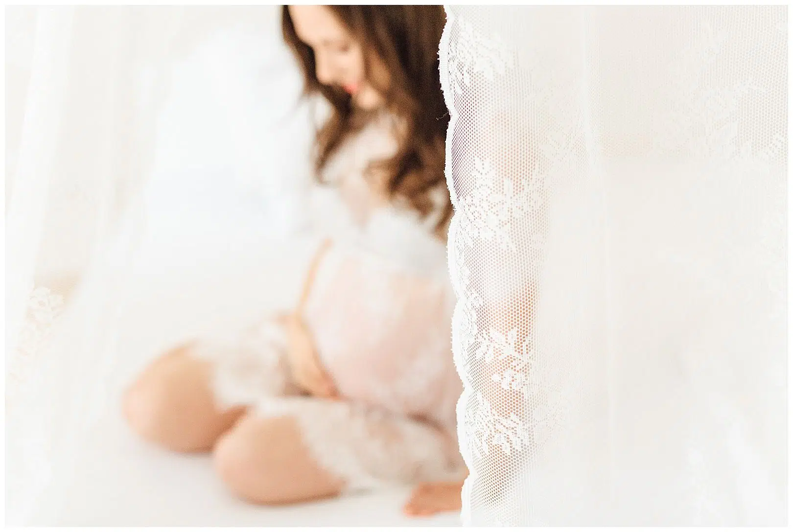 Boudoirfoto einer schwangeren Frau im Spitzenkleid
