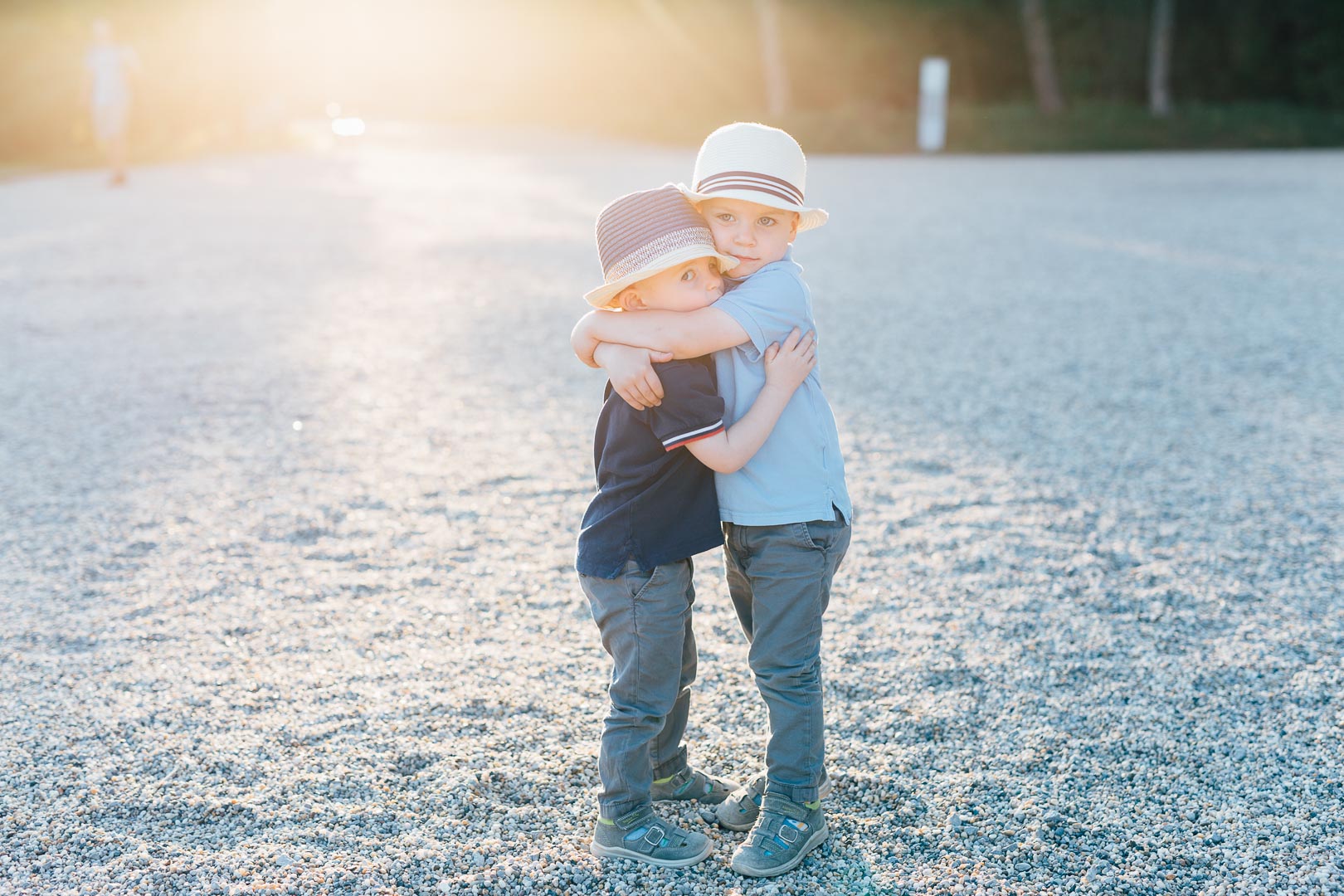 Zwei Jungen mit Hüten umarmen sich