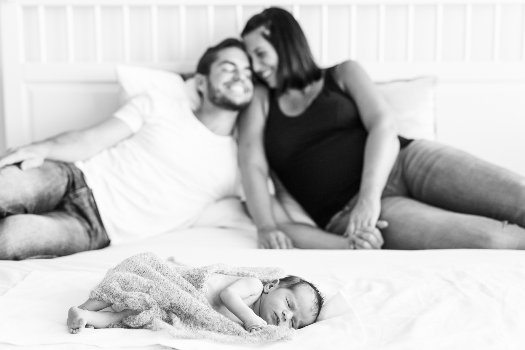 Newbornfotos mit Baby und Eltern im Hintergrund