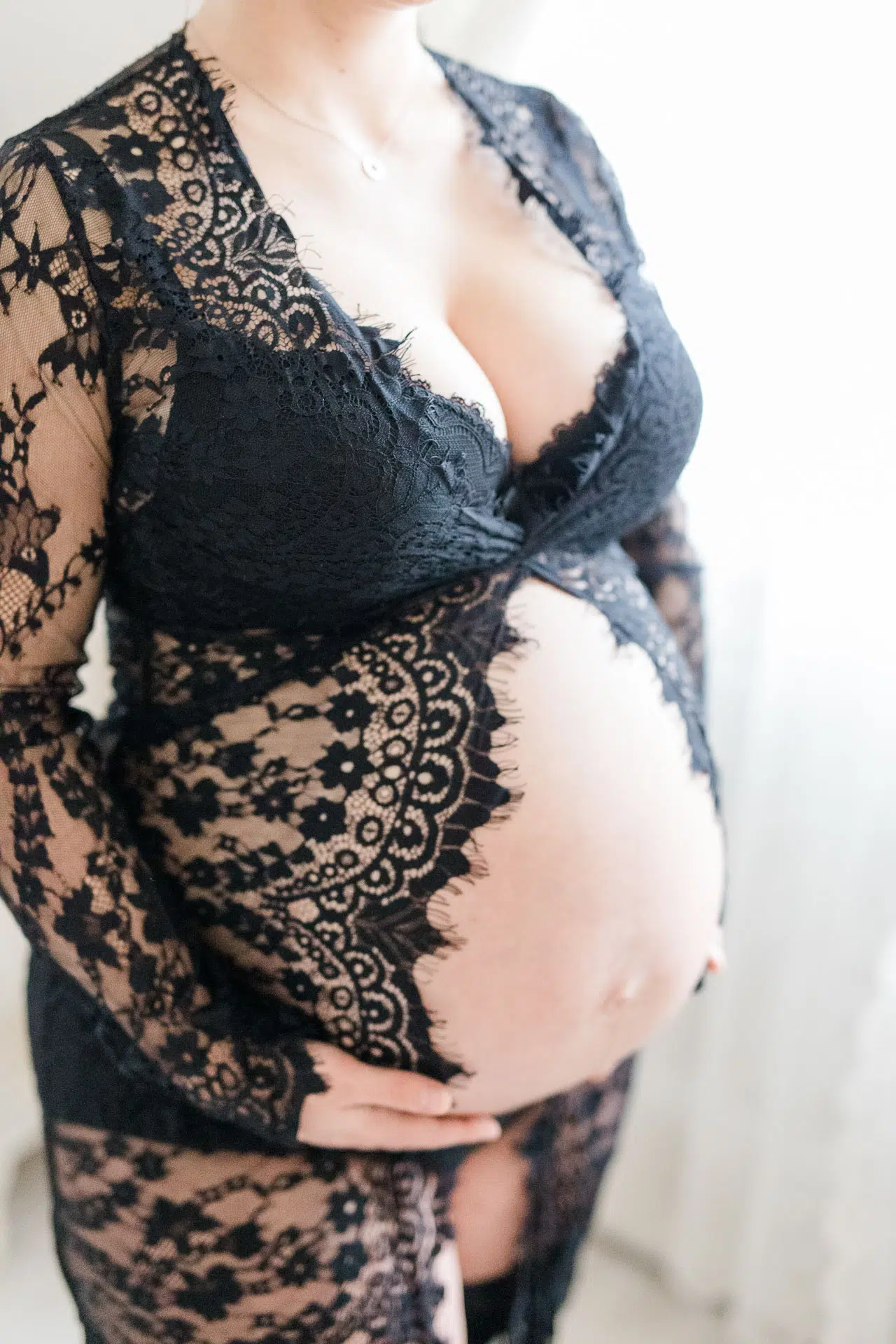 Unterkörper einer Schwangeren, die ihren nackten Bauch hält