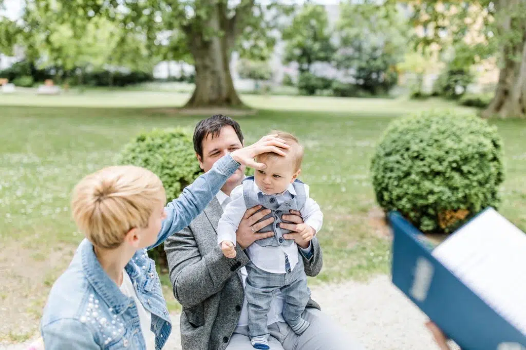 eine Frau macht ein Kreuzzeichen auf die Stirn eines Babys bei einer freien Taufe