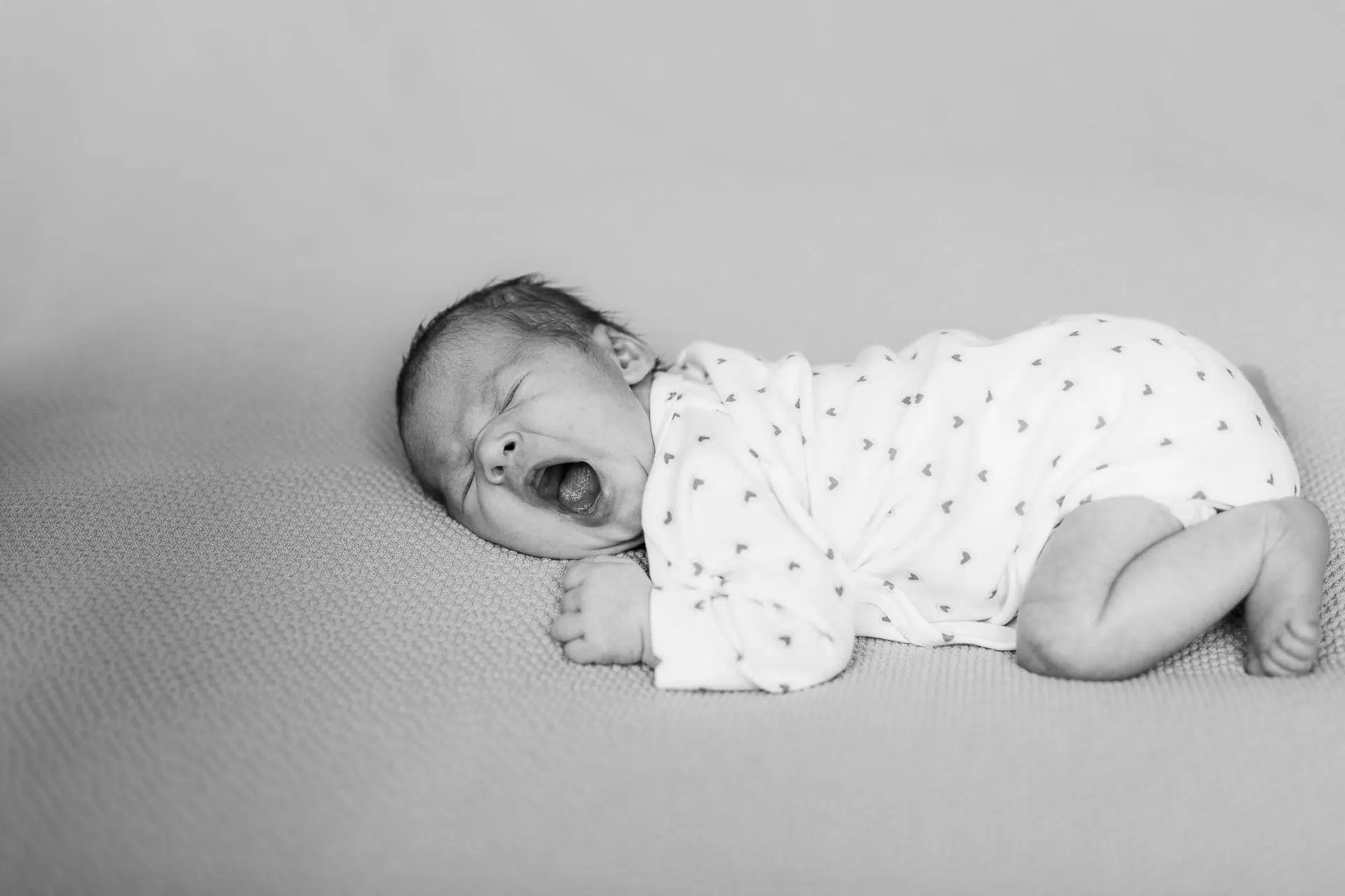 Gutschein-Baby- Carmen-Trappenberg-Fotografie-1-2 ein gähnendes Baby in weißem Body