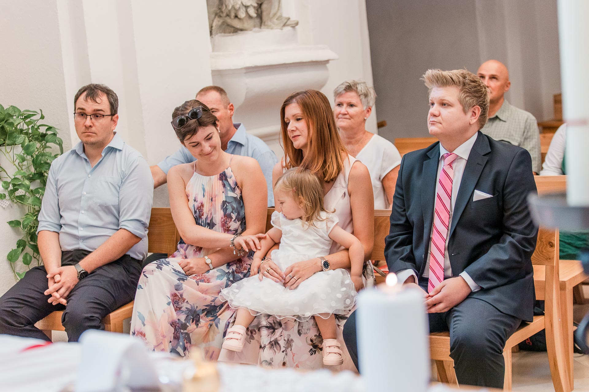 Eine Familie in einer Kirche bei einer Taufe in Wiener Neustadt