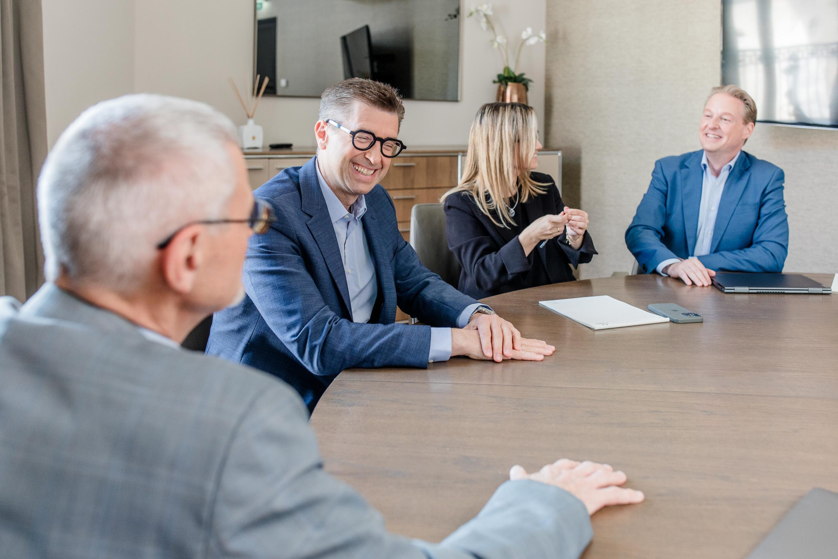 Mitarbeiter im Gespräch am Konferenztisch im Büro.